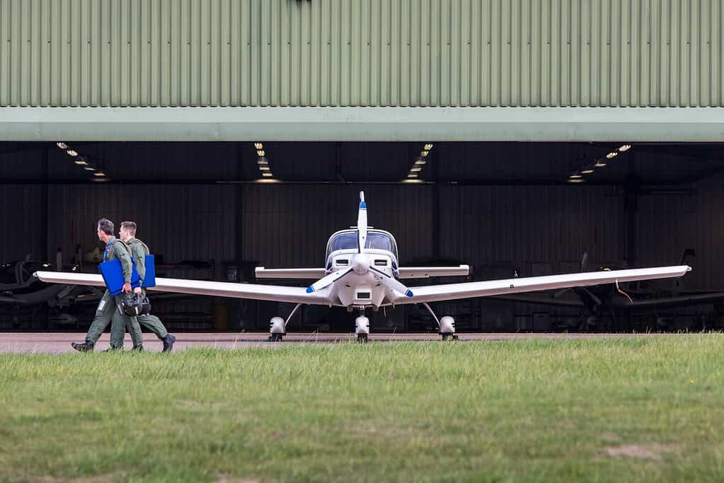 Troops walking in front of a light aircraft
