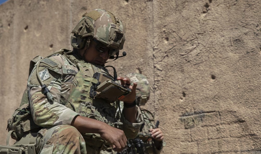 US soldier checks operational data on his end-user device during a field training exercise that demonstrates next-generation command and control radio technology.