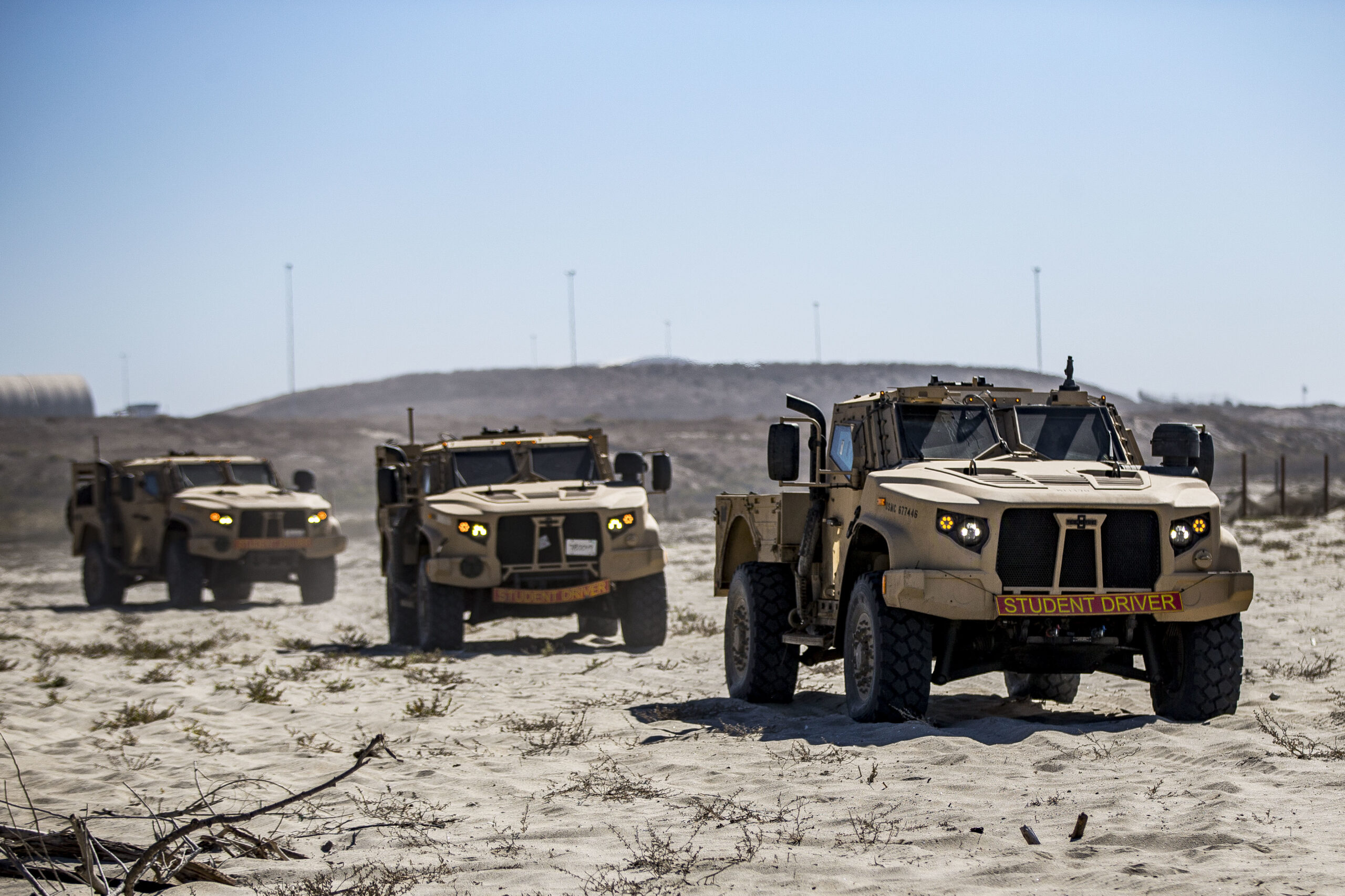 U.S. Marines drive Joint Light Tactical Vehicles at White Beach as part of the I Marine Expeditionary Force JLTV Operator New Equipment Training course on Marine Corps Base Camp Pendleton, California, Oct. 24, 2019. The beach training teaches Marines how to operate JLTVs on different types of terrain. The JLTV OPNET course is an eight-day training evolution teaching students the vehicle’s characteristics, operations, operator maintenance and safety. (U.S. Marine Corps photo by Lance Cpl. Drake Nickels)