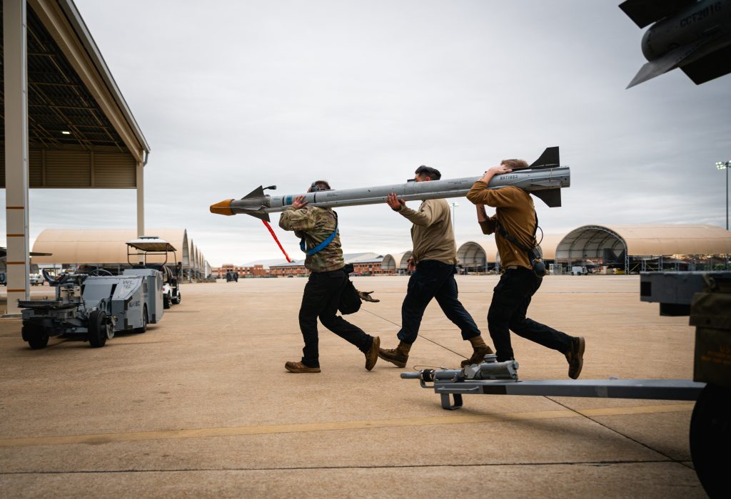 U.S. Airmen with the 94th Fighter Squadron, hurry to load an AIM-9 sidewinder