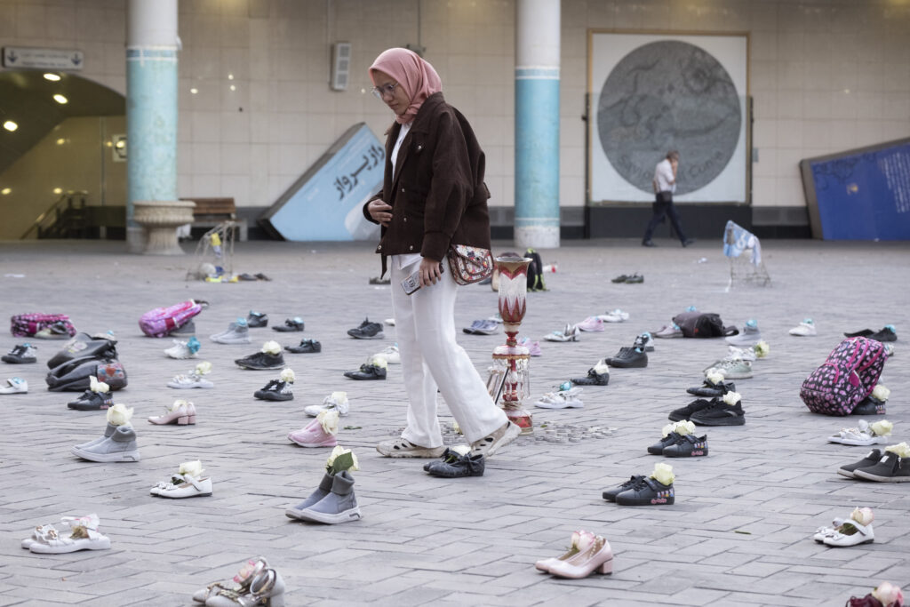 A woman walks through an installation symbolizing the Shajareh Tayyebeh School in Minab, which was destroyed in an airstrike, in a business district of Tehran, Iran, on April 22, 2026, as a ceasefire is extended.