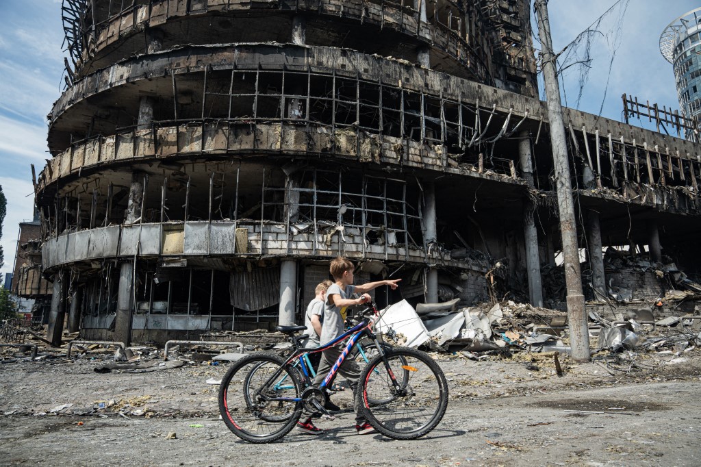 Children walk past a heavily damaged shopping center in Kyiv, Ukraine, on May 24, 2026, after Russian strikes.
