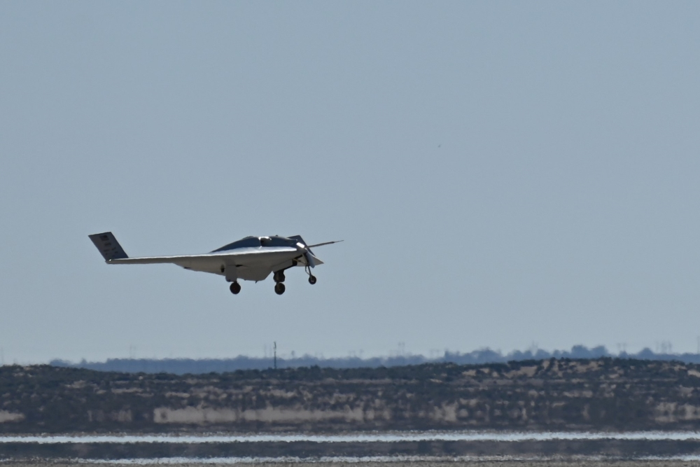 Northrop Grumman XRQ-73 experimental stealth drone on its first flight with landing gear down over an arid landscape